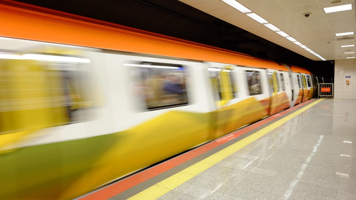 Colorful subway train in motion at an underground station, highlighting urban transit.